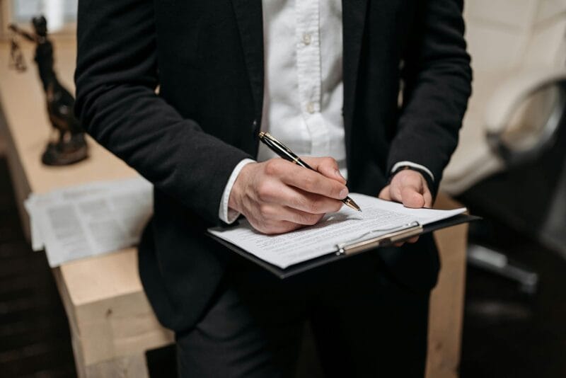 Person writing on clipboard