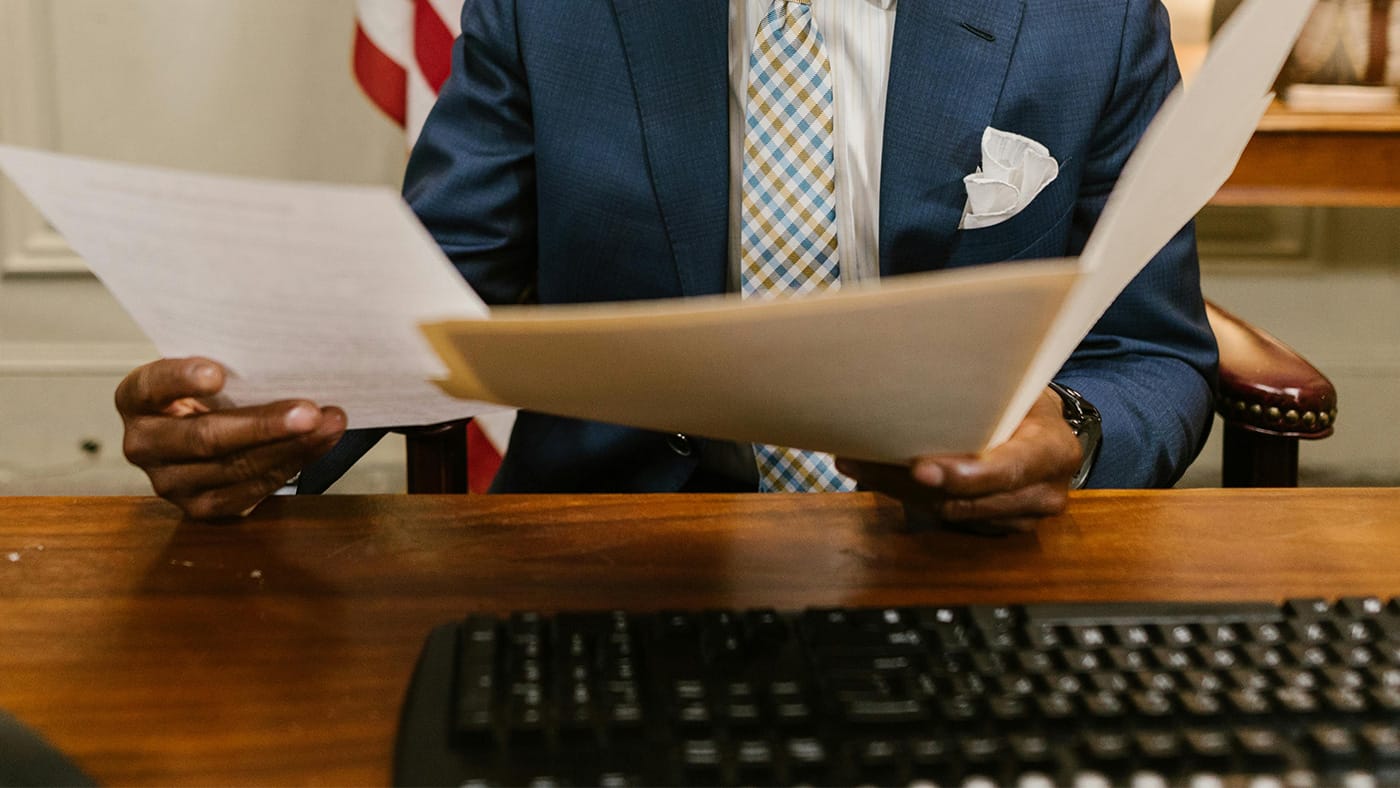 A Man in Blue Suit Jacket Holding Legal Documents